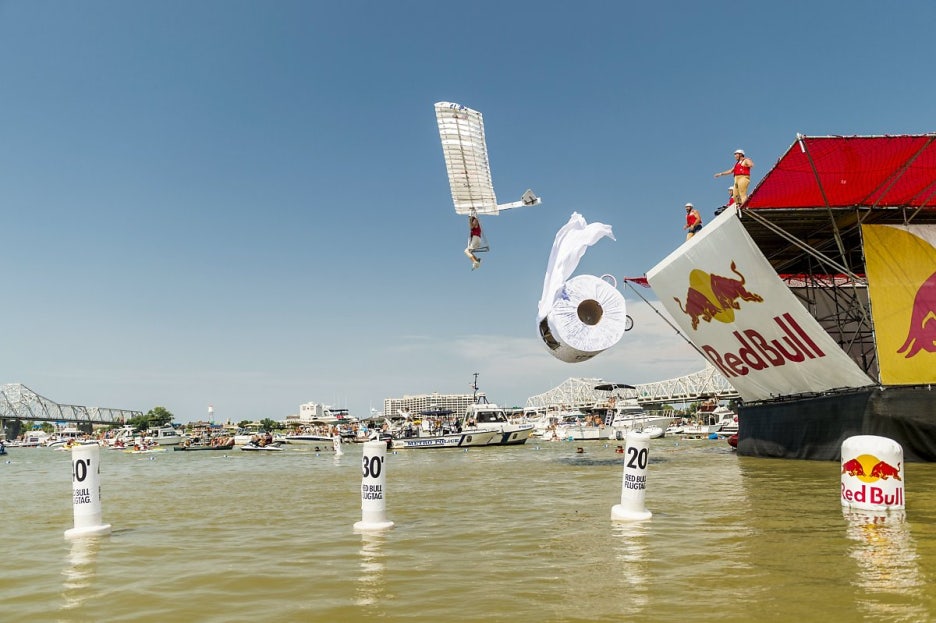 레드불이 주최하는 인력 비행기 대회에서 똥 옷을 입은 참가자가 두루마리 휴지로 만든 비행기를 타고 날고 있다. 매우 인상적이다!