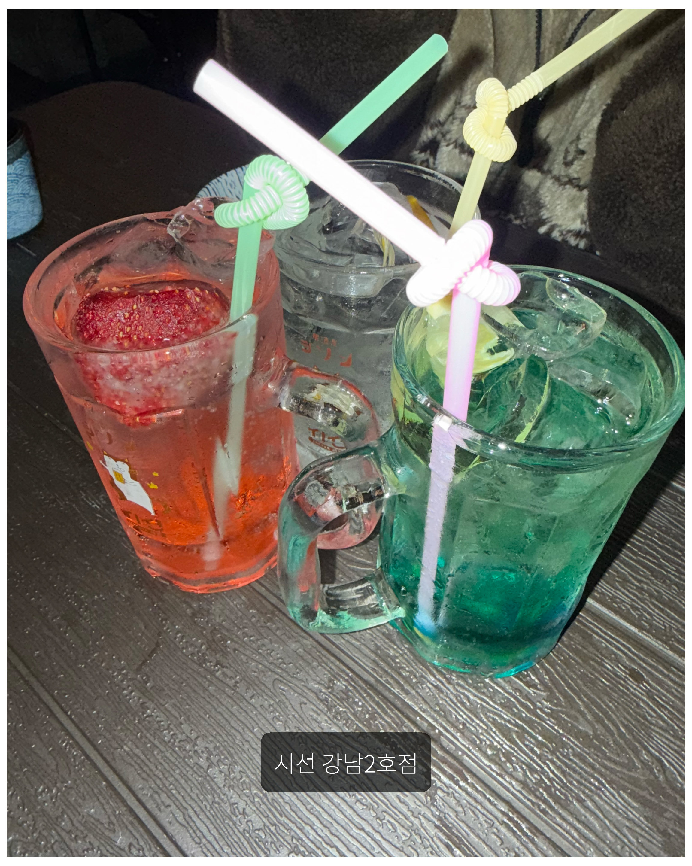 모양 빨대가 꽂힌 딸기 음료 및 초록색 하이볼 음료 3잔