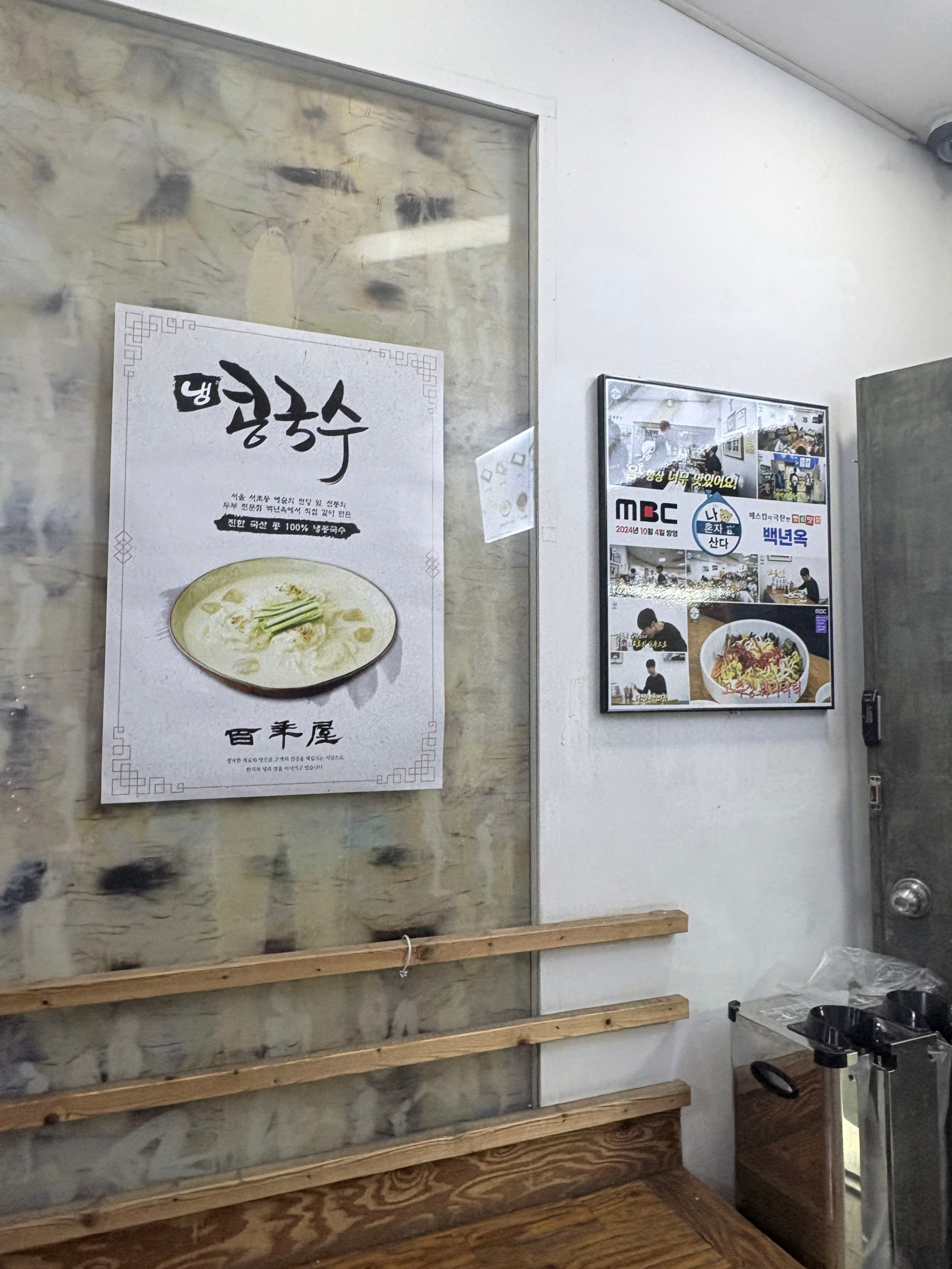 식당 내부 벽면에 부착된 냉콩국수 포스터와 방송 출연 액자