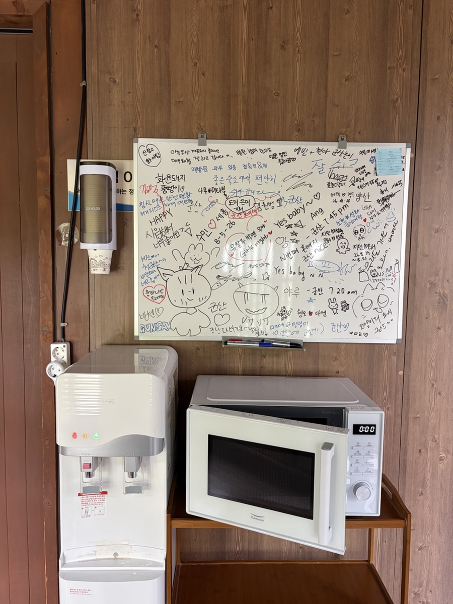 정수기와 전자레인지, 메모가 적힌 화이트보드가 놓여 있습니다.